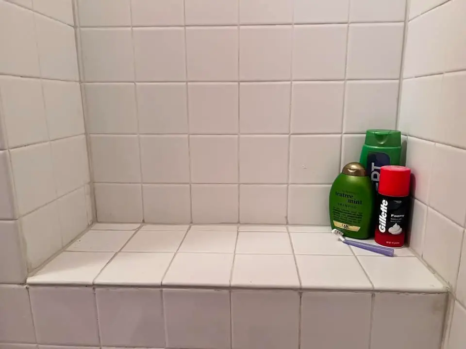 The same shower bench retiled and regrouted in white tile